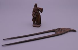 A small 19th century carved wooden model of The Madonna and Child, and a Japanese hair pin.