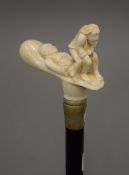 A walking stick with a carved bone handle formed as an amorous couple. 89 cm long.