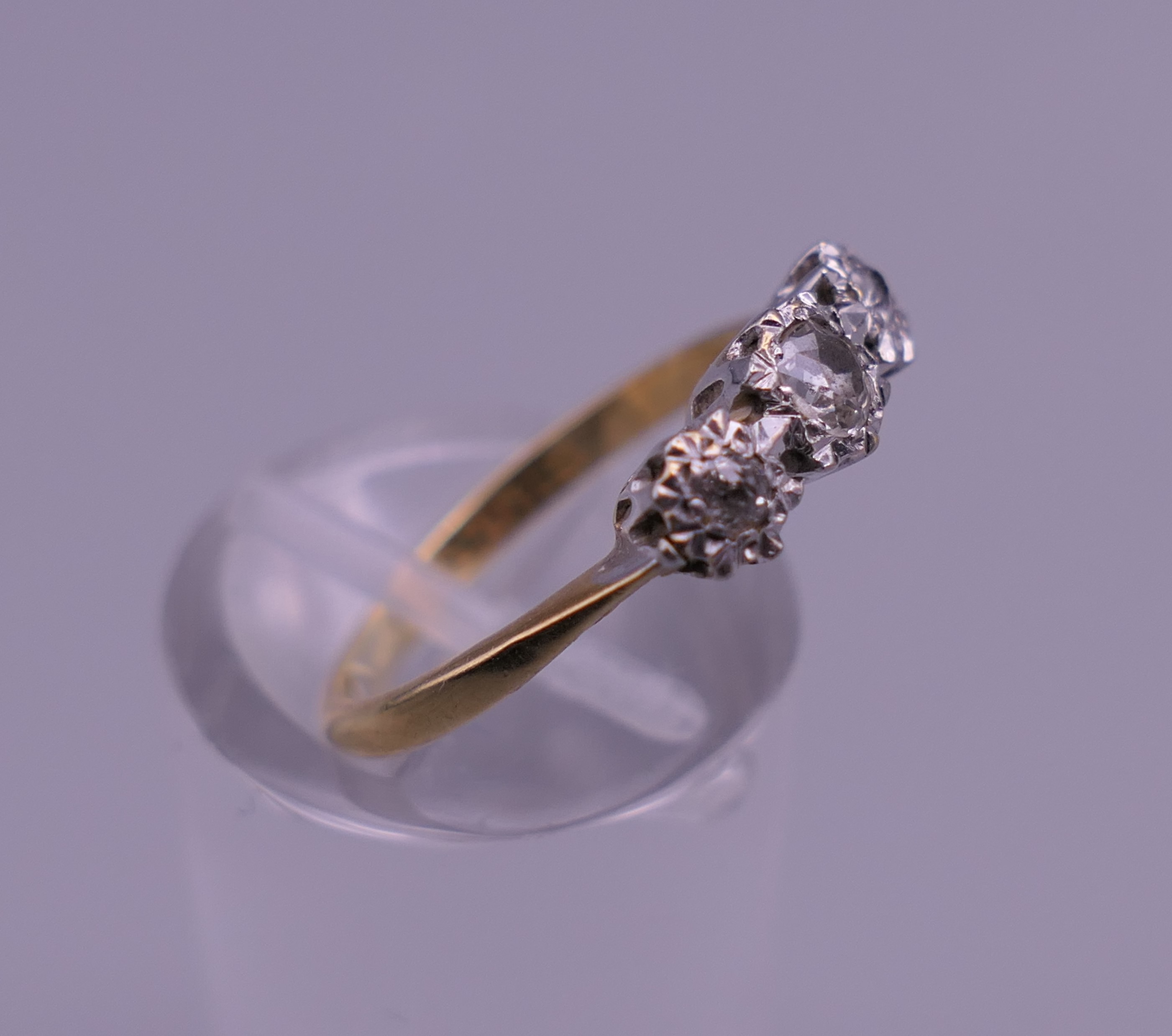 An 18 ct gold and platinum three stone diamond ring. Ring size J/K. 2.3 grammes total weight. - Image 2 of 6