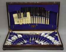 An oak cased canteen of various plated cutlery.