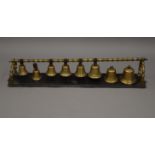 A set of eight 19th century brass hanging bells. 86 cm long.