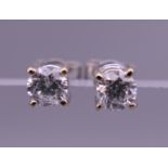 A pair of 18 ct white gold solitaire diamond earrings. 4 mm wide.