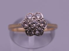 A 9 ct gold and diamond flowerhead ring. Ring size M/N. 2.6 grammes total weight.