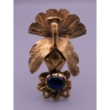 A Persian brooch in the form of a peacock with glass cabochon. 5.5 cm high.