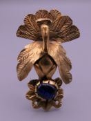 A Persian brooch in the form of a peacock with glass cabochon. 5.5 cm high.