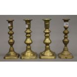 Four 19th century brass ejector candlesticks. Each approximately 20 cm high.
