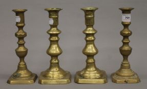 Four 19th century brass ejector candlesticks. Each approximately 20 cm high.