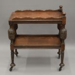 An early 20th century carved oak tea trolley. 74 cm long.