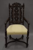 A Victorian carved oak open arm chair. 62 cm wide.