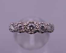 An 18 ct gold five stone diamond ring. Ring size Q/R. 3.9 grammes total weight.