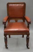 An oak leather upholstered open arm chair. 58.