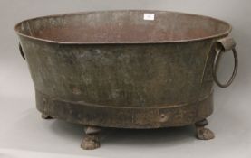 An antique twin handled metal planter with paw feet. 78 cm wide.