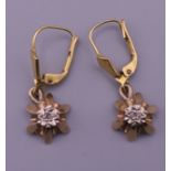 A pair of 9 ct gold diamond set drop earrings. 2 cm high. 3.2 grammes total weight.