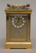 A brass cased repeating alarm clock. 18.5 cm high.
