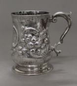 An embossed silver tankard. 12 cm high. 11.9 troy ounces.