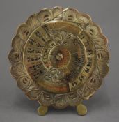 A brass 20 year calendar. 8 cm diameter.