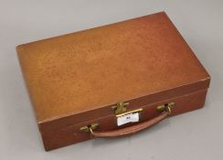 A leather writing case with inkwell, letter opener and pens. 30.5 cm wide.