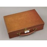 A leather writing case with inkwell, letter opener and pens. 30.5 cm wide.