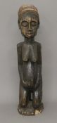 An African tribal carved wooden fertility figure mounted with beads and cowry shells. 75 cm high.