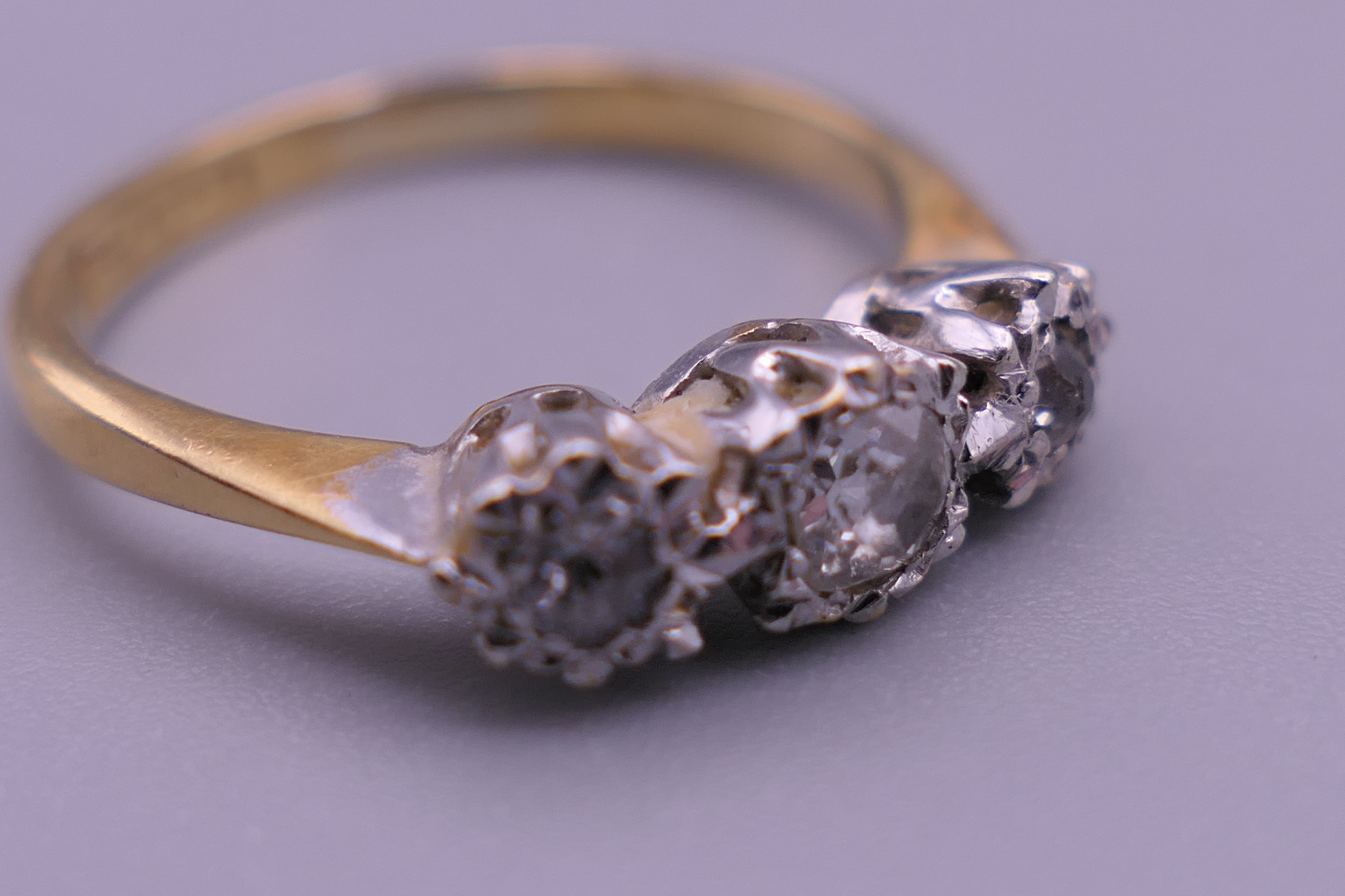 An 18 ct gold and platinum three stone diamond ring. Ring size J/K. 2.3 grammes total weight. - Image 6 of 6