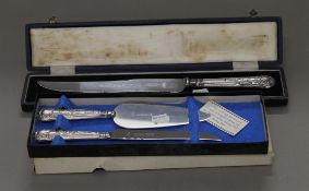 A cased silver plated cake knife inscribed for Huntley and Palmers,