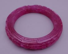 A ruby jade bangle. 5.75 cm inner diameter.