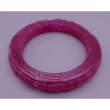 A ruby jade bangle. 5.75 cm inner diameter.