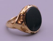 An 18 ct gold and blood stone signet ring. Ring size O/P. 11.5 grammes total weight.