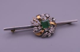 An unmarked gold diamond and emerald bar brooch. 5.5 cm long. 7 grammes total weight.