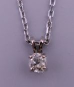 A white gold and diamond pendant on chain. The pendant 7 mm high. 5 grammes total weight.