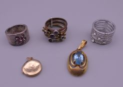 Three rings (one Swarovski), a cross pendant, a locket and another pendant.