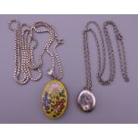 An enamel decorated silver locket on chain and another. The former 3.5 cm high.