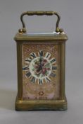 A brass cased carriage clock with painted porcelain panels. 14 cm high.