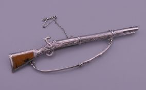 An unmarked silver hardstone set brooch formed as a rifle. 11 cm long.