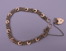 A 9 ct gold bracelet with horseshoes and padlock fastener. 18 cm long. 10 grammes.