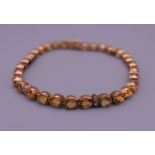 A 14 ct gold citrine and diamond tennis bracelet. 17.5 cm long. 10.6 grammes total weight.