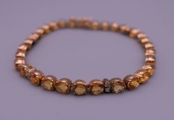 A 14 ct gold citrine and diamond tennis bracelet. 17.5 cm long. 10.6 grammes total weight.