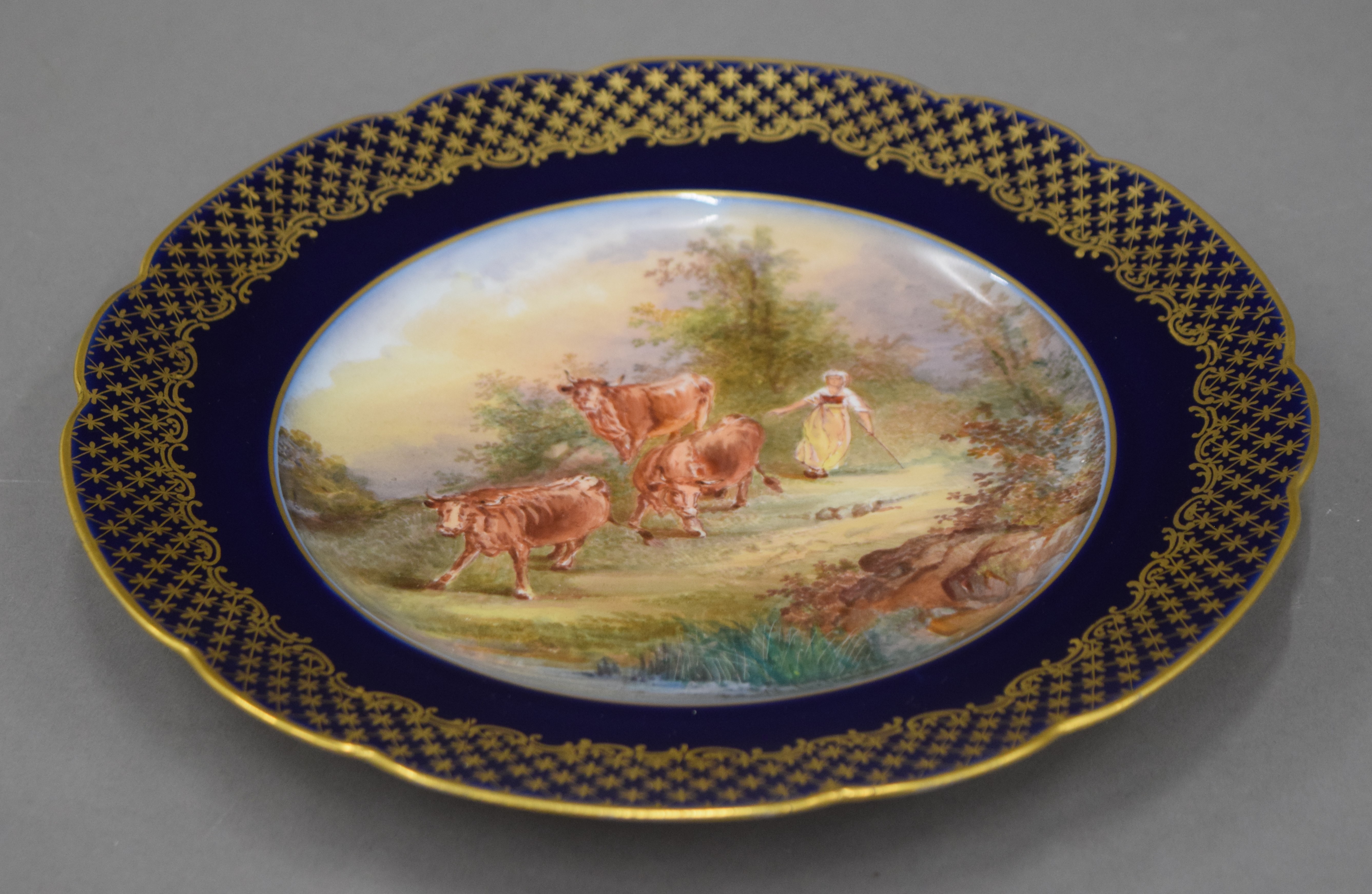 A Continental porcelain plate painted with cattle, signed L Malerbaud. 23 cm diameter.