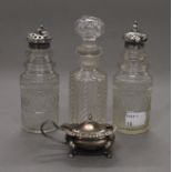 A silver mustard pot, two silver topped cut glass sifters and a cut glass jar.