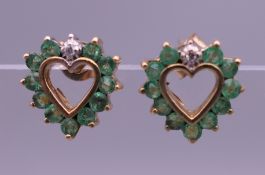 A pair of 9 ct gold emerald and diamond heart shaped earrings. 9 mm high.