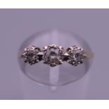An 18 ct gold and platinum three stone diamond ring. Ring size J/K. 2.3 grammes total weight.