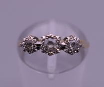 An 18 ct gold and platinum three stone diamond ring. Ring size J/K. 2.3 grammes total weight.