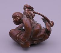 An Oriental carving formed as a man with a fish. 4.5 cm long.