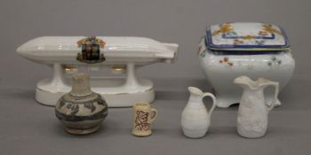 A crested ware air ship, a Japanese porcelain box and four miniature pottery vessels.