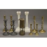 A quantity of various candlesticks and a miner's lamp.