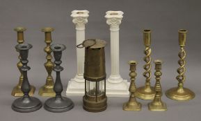 A quantity of various candlesticks and a miner's lamp.