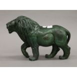 A green verdite stone sculpture of a standing lion, signed A Chauke. 18 cm high, 26.5 cm long.