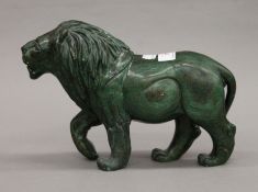A green verdite stone sculpture of a standing lion, signed A Chauke. 18 cm high, 26.5 cm long.