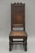A 17th/18th century oak single chair with high panelled back. 48 cm wide.