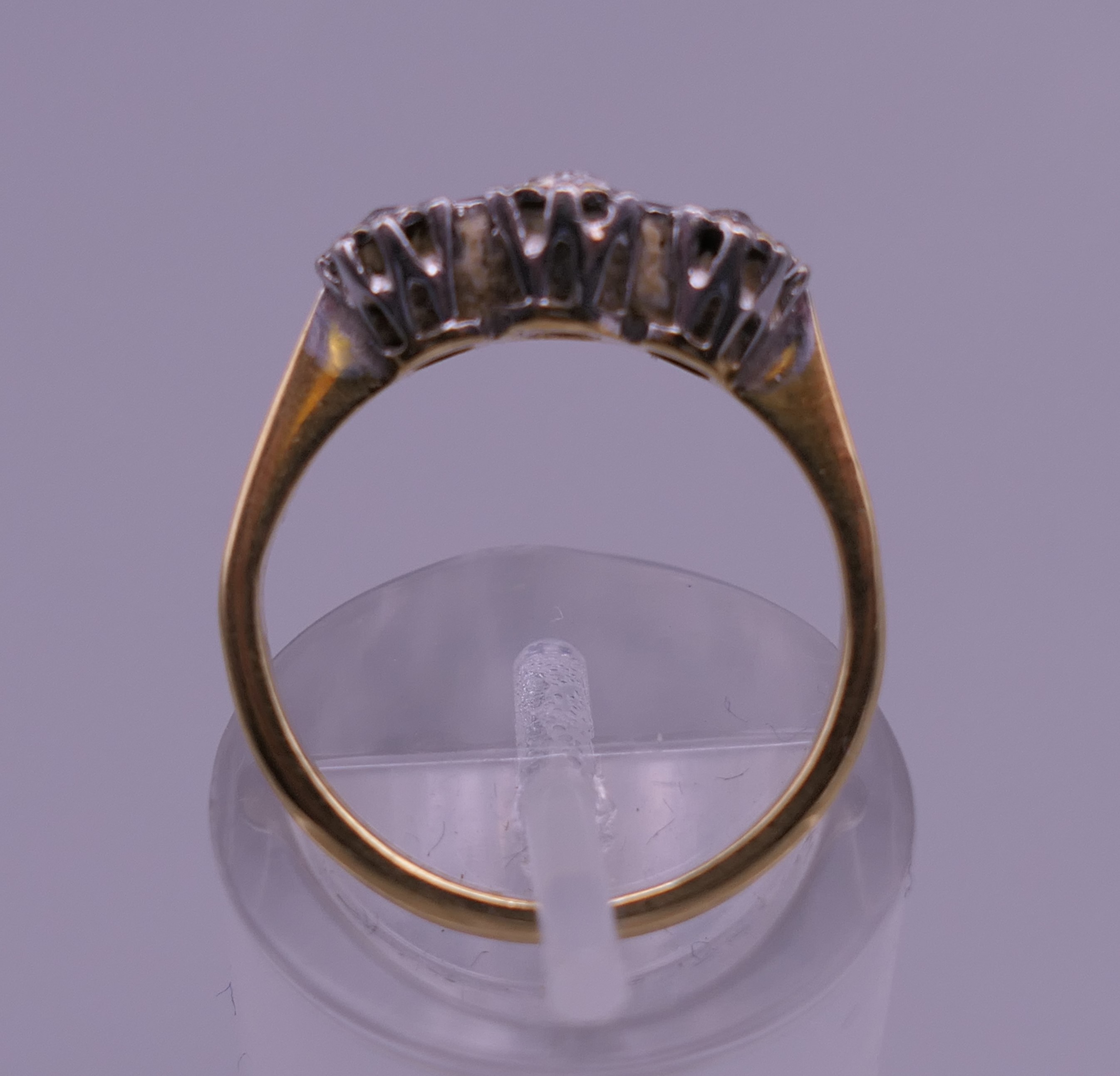 An 18 ct gold and platinum three stone diamond ring. Ring size J/K. 2.3 grammes total weight. - Image 3 of 6